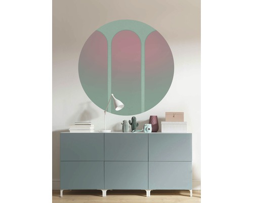 Wanddecoratie met een cirkelvormige muursticker boven een dressoir met decoraties.