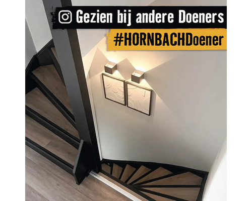 Trap met houten treden, wandlampen en twee ingelijste afbeeldingen