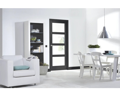 Lichte woonkamer met deur, plank, fauteuil en eettafel