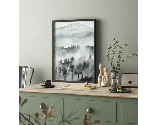 Ingelijste afbeelding met aquarel van een berglandschap op een tafel