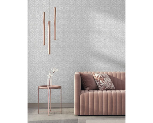 Woonkamer met patroonbehang, bank, tafel en hanglampen