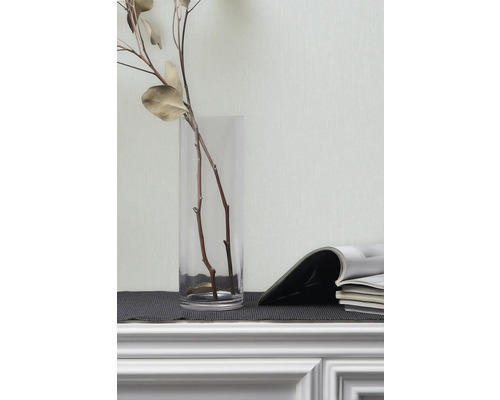 Decoratieve takken in glazen vaas en tijdschriften op een plank