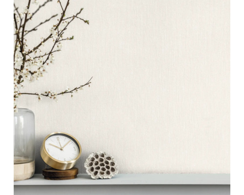 Decoratieve opstelling met vaas, bloeiende takken, tafelklok en gedroogde lotusbloem op een plank.