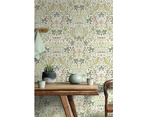 Woonkamer met patroonbehang met vogel- en plantmotief achter een houten tafel