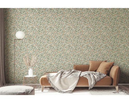 Woonkamer met bloemenbehang, bank en vloerlamp.