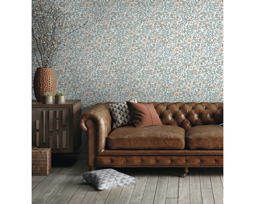 Woonkamer met bloemenbehang, leren bank en houten meubels voor een gezellige sfeer