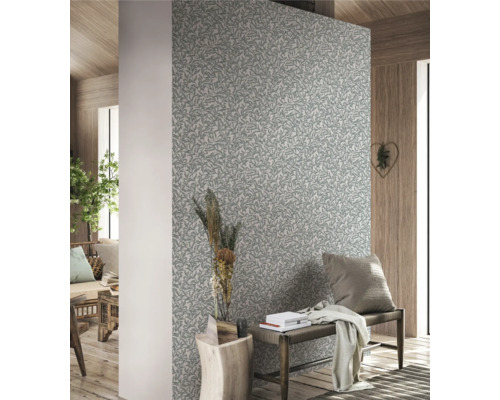 Woonkamer met patroonbehang, zitbank en decoraties voor een gezellige sfeer.