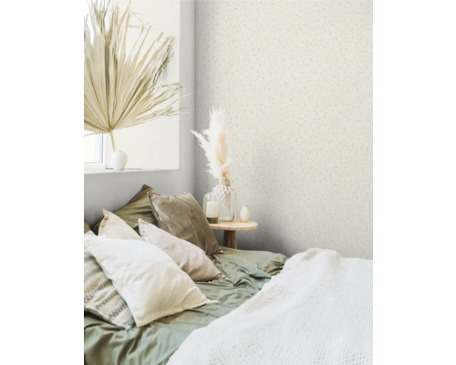 Slaapkamer met behang met patroon, bed met kussens en decoraties.