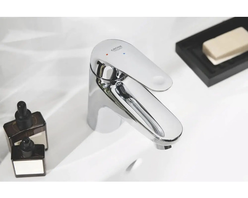 Glanzende Grohe kraan op een wastafel met verzorgingsproducten