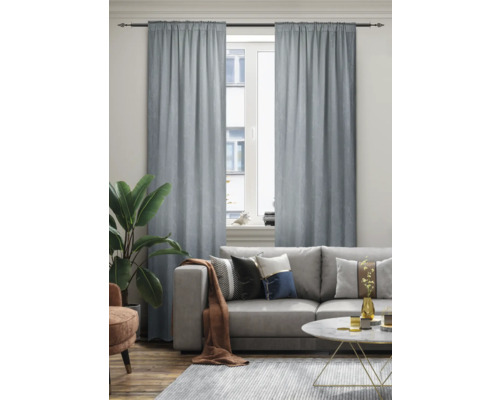 Woonkamer met bank, vloerkleed en gordijnen voor het raam