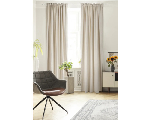 Lichte woonkamer met gordijnen, fauteuil, vloerkleed en decoratie