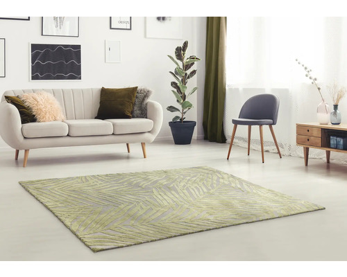 Woonkamer met een vloerkleed met patroon, bank, stoel en kamerplant