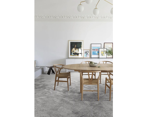 Lichte kamer met eettafel, stoelen en kunstwerken aan de muur