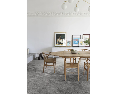 Eetkamer met ovale houten tafel, stoelen en tapijt