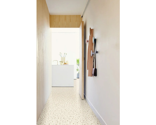 Hal met terrazzovloer, kapstok en uitzicht op een lichte kamer