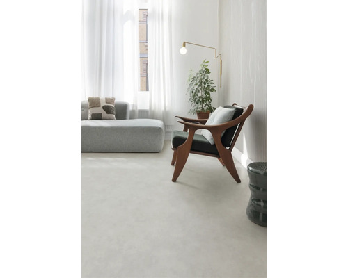 Lichte woonkamer met bank, fauteuil, vloerlamp en kamerplant