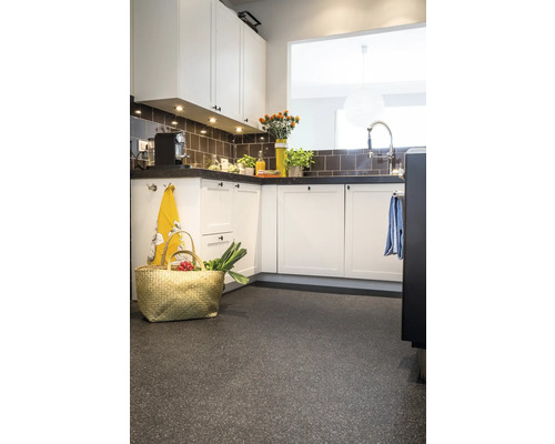 Lichte keuken met aanrecht, kasten, tegels en een mand op de vloer.