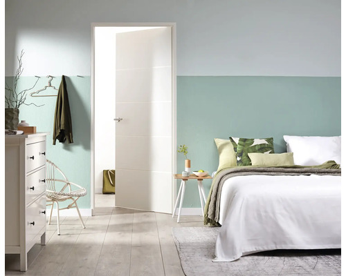 Lichte slaapkamer met bed, ladekast, stoel en open binnendeur