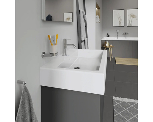 Moderne badkamer met wastafel, kraan, spiegel en handdoekhouder.