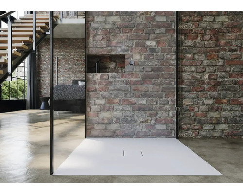 Moderne douche met vlakke douchebak en glazen wand voor een bakstenen muur.