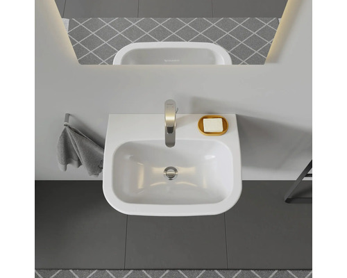 Bovenaanzicht van een wastafel met kraan en zeep in de badkamer