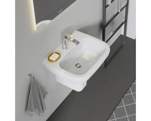 Foto van een badkamer met een witte wastafel, een zeepbakje en een kraan.