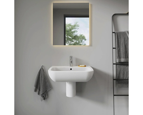 Moderne badkamer met wastafel, wastafelzuil en verlichte spiegel