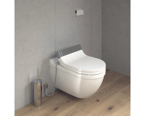 Scene met douchetoilet, bedieningspaneel en toiletborstel in de badkamer