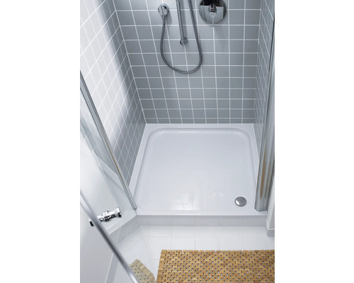 Douchecabine met douchebak, armatuur en grijs betegelde wand