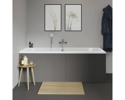 Badkamer met bad, kraan, douchekop, badkruk, badmat en decoratie