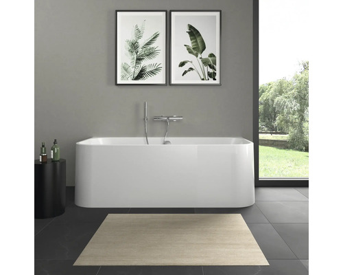 Badkamer met vrijstaand bad, tapijt en plantenafbeeldingen