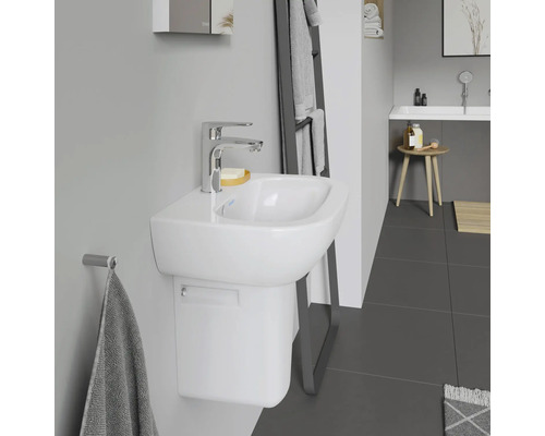 Badkamer met witte wastafel, kraan en handdoekhouder.