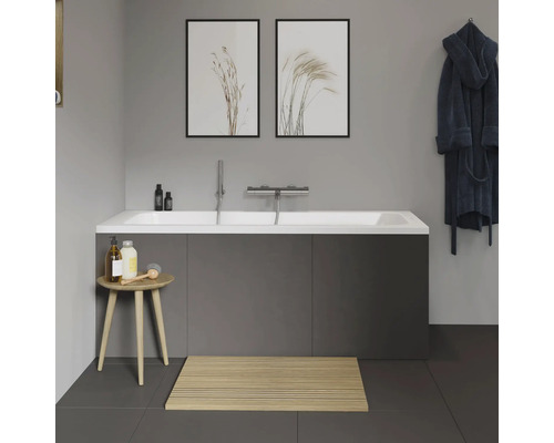 Moderne badkamer met bad, houten badmat en decoratie