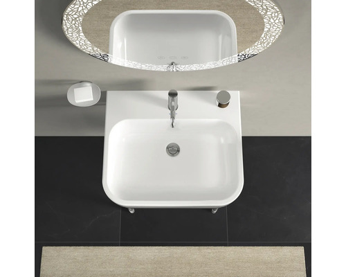 Bovenaanzicht van een wastafel met kraan, zeepbakje en verlichte spiegel in een badkamer.