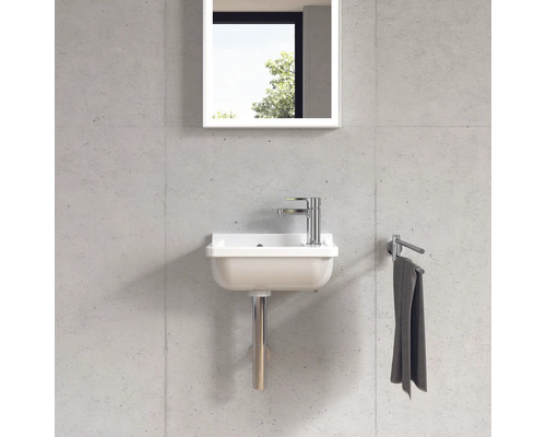 Compacte wastafel met kraan, spiegel en handdoekhouder aan een wand gemonteerd.