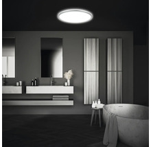 Moderne badkamer met ronde plafondlamp, wastafels, spiegels en bad