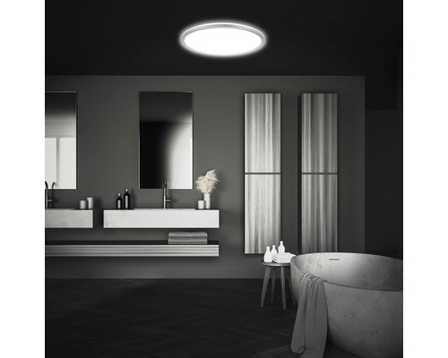 Moderne badkamer met ronde plafondlamp, wastafels, spiegels en bad