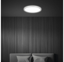 Kamerzicht met ronde plafondlamp boven een bed