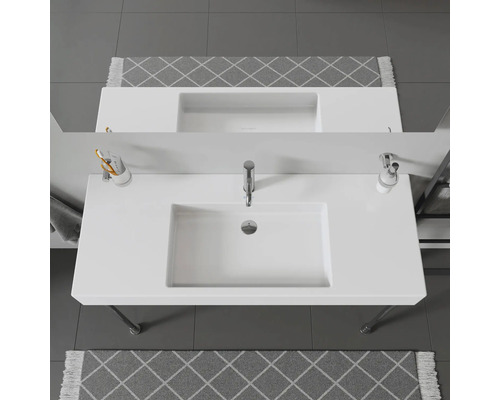Bovenaanzicht van een badkamer met witte wastafel en grijs vloerkleed