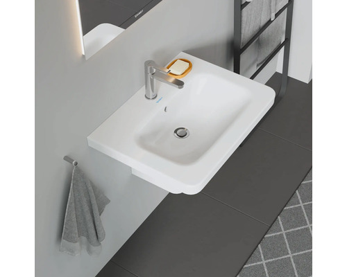 Witte opzetwastafel met kraan, zeepbakje en handdoekhouder in de badkamer.