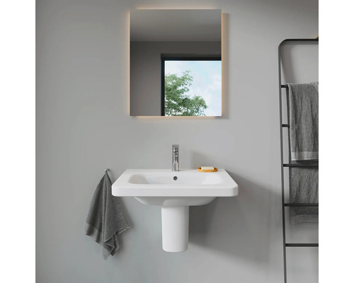 Badkamer met wastafel, verlichte spiegel en handdoekrek