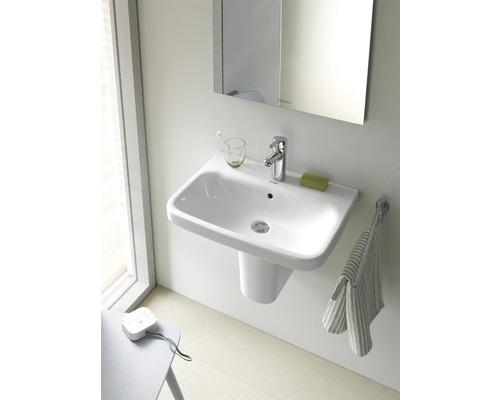 Wastafel met kraan, zeep en handdoek in de badkamer