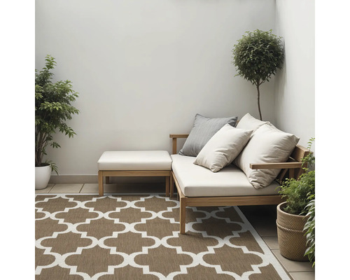 Tuinscene met loungesofa, voetenbank, sierkussens, planten en buitenkleed met patroon