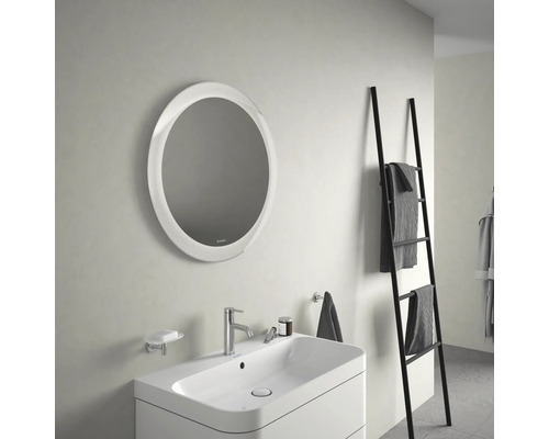 Badkamer met ronde spiegel, wastafel en handdoekladder