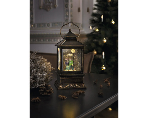 Decoratieve lantaarn met sneeuwbol en figurenpaar op tafel met kerstdecoratie