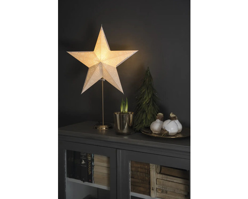 Decoratieve scène met verlichte ster, bolplanten en kleine kerstboom op een kast