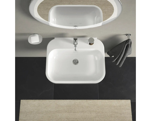 Bovenaanzicht van een badkamer met wastafel, spiegel, zeepbakje en handdoekhouder