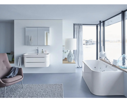 Lichte badkamer met wastafel, spiegelkast, bad en fauteuil voor een moderne sfeer.