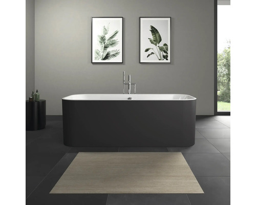 Vrijstaand bad in een badkamer met afbeeldingen van planten aan de muur