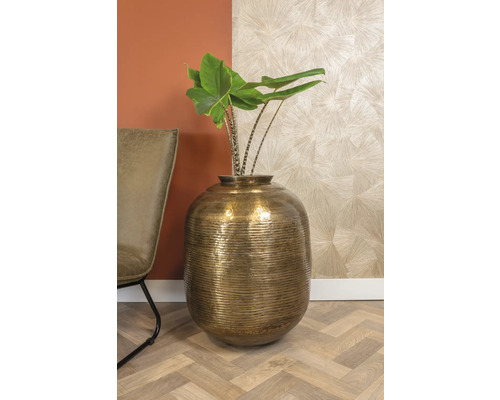 Decoratieve goudkleurige vaas met plant in interieur